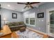 A cozy living room with a large couch, ceiling fan, hardwood floors and natural light from the windows at 319 Beacon Hills Dr, Gastonia, NC 28056
