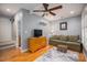 A cozy living room with a large couch, ceiling fan, hardwood floors and a mounted fish decoration at 319 Beacon Hills Dr, Gastonia, NC 28056