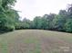 Expansive grassy backyard surrounded by mature trees, perfect for outdoor activities and enjoying nature at 3750 Turner Rd, Clover, SC 29710