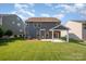Back exterior view of home with a covered patio, lush green lawn and attractive landscaping at 4324 Falls Lake Sw Dr, Concord, NC 28025