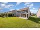 A spacious backyard featuring a covered patio, lush green lawn, and well-maintained landscaping at 4324 Falls Lake Sw Dr, Concord, NC 28025