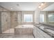 Elegant bathroom features a glass shower, soaking tub, and white double vanity at 4324 Falls Lake Sw Dr, Concord, NC 28025