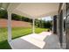 Covered patio featuring a concrete floor, white columns, and a view of the landscaped backyard at 4324 Falls Lake Sw Dr, Concord, NC 28025