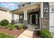 Inviting front porch with stone pillars, a dark front door, and manicured landscaping at 4324 Falls Lake Sw Dr, Concord, NC 28025