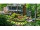 Expansive brick home featuring a spacious screened porch and beautifully landscaped backyard with lush gardens and a seating area at 4647 16Th Street Ne Pl, Hickory, NC 28601