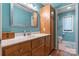 Well-lit bathroom featuring tiled flooring, a large mirror, and wood cabinetry at 4647 16Th Street Ne Pl, Hickory, NC 28601