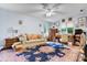 Bright living room with a ceiling fan, desk, sofa, and an ornate area rug at 4647 16Th Street Ne Pl, Hickory, NC 28601