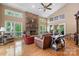 Bright living room with a soaring ceiling, stone fireplace, and large windows offering serene views of the surrounding nature at 4647 16Th Street Ne Pl, Hickory, NC 28601