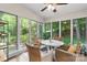 Bright sunroom with wicker chairs surrounding a white marble table, with a view of the surrounding trees at 4647 16Th Street Ne Pl, Hickory, NC 28601