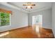 Bright living room with beautiful hardwood floors and a tray ceiling with ceiling fan at 5028 Polo Gate Blvd, Charlotte, NC 28216