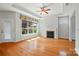 Spacious living room with hardwood floors, fireplace, tray ceiling, and a wall of windows at 5028 Polo Gate Blvd, Charlotte, NC 28216