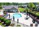 Community pool surrounded by lounge chairs, tables, umbrellas, and lush landscaping at 5028 Polo Gate Blvd, Charlotte, NC 28216