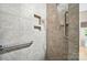 Walk-in shower featuring tiled walls with built-in niches and grab bars at 5028 Polo Gate Blvd, Charlotte, NC 28216