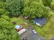 An aerial view showcases a large lot with a house, a recreational area with a pool, and mature trees at 5240 Old Monroe Rd, Indian Trail, NC 28079