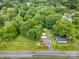 An aerial view shows a home with mature trees, long driveway, recreational area, and spacious surroundings at 5240 Old Monroe Rd, Indian Trail, NC 28079