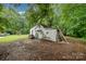 The backyard features an outbuilding/shed with overgrown greenery, and recreational equipment amidst mature trees at 5240 Old Monroe Rd, Indian Trail, NC 28079