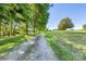 Long gravel driveway leading to a house on a grassy hill at 5710 Lander Benton Rd, Unionville, NC 28110