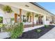 Inviting covered front porch with white brick, wooden columns and hanging plants at 5710 Lander Benton Rd, Unionville, NC 28110