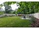 Expansive backyard features a round patio with chairs, lush lawn, and privacy fence at 5777 Stephanie St, Charlotte, NC 28212