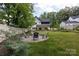 An inviting backyard features a round patio with seating, green lawn, and hammock at 5777 Stephanie St, Charlotte, NC 28212