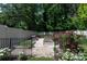 Enclosed backyard garden features raised garden beds with gravel paths and a variety of flowering plants at 5777 Stephanie St, Charlotte, NC 28212