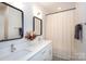 Bright bathroom features a double vanity with modern sinks and a shower with a shower curtain at 5777 Stephanie St, Charlotte, NC 28212