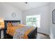 Cozy bedroom with wooden bed frame, neutral color palette, and a window overlooking the backyard at 5777 Stephanie St, Charlotte, NC 28212
