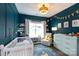 Stylishly decorated Bedroom with a crib, accent wall, changing table, and a comfortable armchair at 5777 Stephanie St, Charlotte, NC 28212