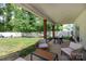 Spacious covered patio featuring seating, a dining table, and views of the well-maintained backyard at 5777 Stephanie St, Charlotte, NC 28212