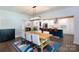 Bright dining area featuring a modern light fixture, adjacent to a kitchen with an island and barstool seating at 5777 Stephanie St, Charlotte, NC 28212