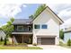 Striking two-story home with white and gray siding, solar panels, and a modern garage door at 5777 Stephanie St, Charlotte, NC 28212