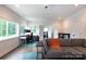 Spacious living area featuring hardwood floors, a gray sofa, and desk space at 5777 Stephanie St, Charlotte, NC 28212