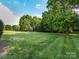 Spacious backyard with lush green grass and mature trees, perfect for outdoor activities at 5822 Alexa Rd, Charlotte, NC 28277