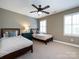 Cozy bedroom with two twin beds, neutral tones, and ample natural light from the shuttered windows at 5822 Alexa Rd, Charlotte, NC 28277