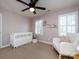 Bedroom complete with a crib, rocking chair, and shelving, filled with books and plush toys at 5822 Alexa Rd, Charlotte, NC 28277