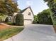 Side view of a bright house, driveway, garage and mature landscaping at 5822 Alexa Rd, Charlotte, NC 28277