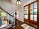 Inviting foyer featuring gleaming hardwood floors, a stylish staircase, and a beautiful front door with sidelights at 5822 Alexa Rd, Charlotte, NC 28277