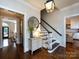 Staircase and foyer area with a decorative mirror, console table, and elegant lighting fixture, leading to other rooms at 5822 Alexa Rd, Charlotte, NC 28277