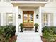 Close-up of the entryway, featuring an inviting front door, elegant lantern fixtures, and beautiful planters with lush greenery at 5822 Alexa Rd, Charlotte, NC 28277