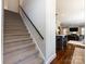 Carpeted stairway leading up to an open-concept living area with hardwood floors and modern lighting at 5822 Alexa Rd, Charlotte, NC 28277