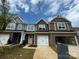 New townhomes with brick and siding exteriors, showcasing modern design and attached garages under a cloudy sky at 6256 Culbert St # 187, Harrisburg, NC 28075