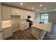 Bright kitchen with stainless steel appliances, white cabinets, quartz countertop island and modern fixtures at 6256 Culbert St # 187, Harrisburg, NC 28075