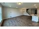 Open-concept living space showing hardwood floors, a kitchen island, staircase, and modern chandelier at 6256 Culbert St # 187, Harrisburg, NC 28075