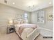 Charming bedroom with a white bedframe, soft pink accents, and a window overlooking the neighborhood at 6274 Chimney Bluff Rd, Lancaster, SC 29720