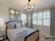 Comfortable bedroom with a statement mirror feature, large window with shutters, and stylish contemporary light fixture at 6274 Chimney Bluff Rd, Lancaster, SC 29720