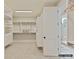 Bright walk-in closet featuring custom white shelving and storage adjacent to an ensuite bathroom with glass enclosed shower at 6274 Chimney Bluff Rd, Lancaster, SC 29720
