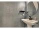 Modern powder room features a pedestal sink, unique wall texture, and round mirror at 8221 Houser St, Cornelius, NC 28031