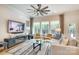 Bright living room features stylish furnishings, large windows, and a ceiling fan at 8221 Houser St, Cornelius, NC 28031