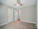Neutral bedroom featuring carpet, ceiling fan, large window and two closets at 8309 Emily Dr, Harrisburg, NC 28075