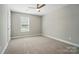 Neutral bedroom featuring plush carpeting, a ceiling fan, and a window at 8309 Emily Dr, Harrisburg, NC 28075